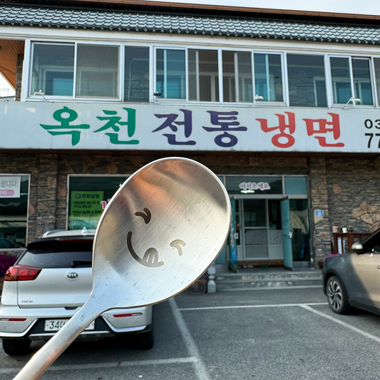 In front of the naengmyeon restaurant, the spoon has an expression of eager anticipation.