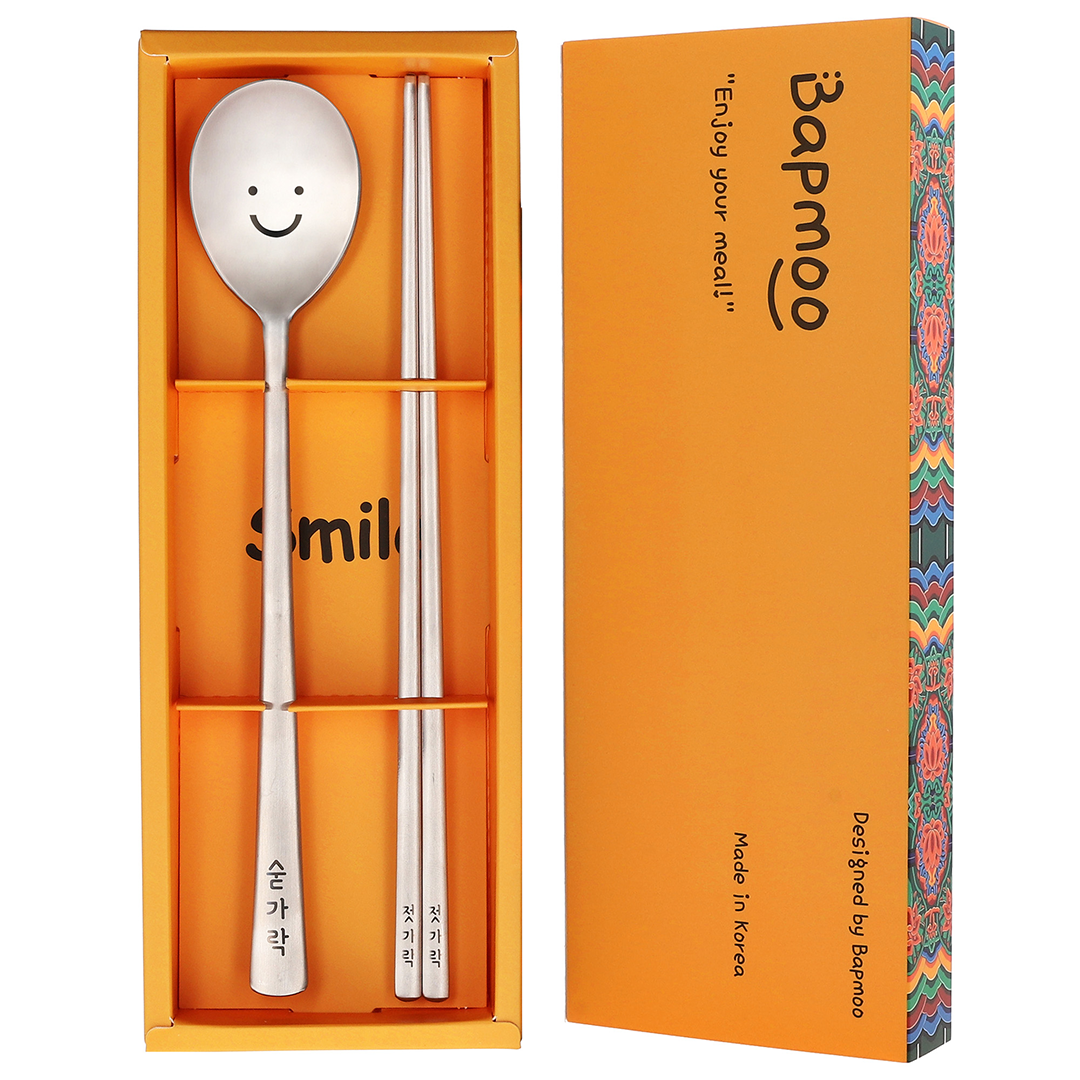 The spoon and chopsticks are placed in a yellow box with a dancheong pattern.