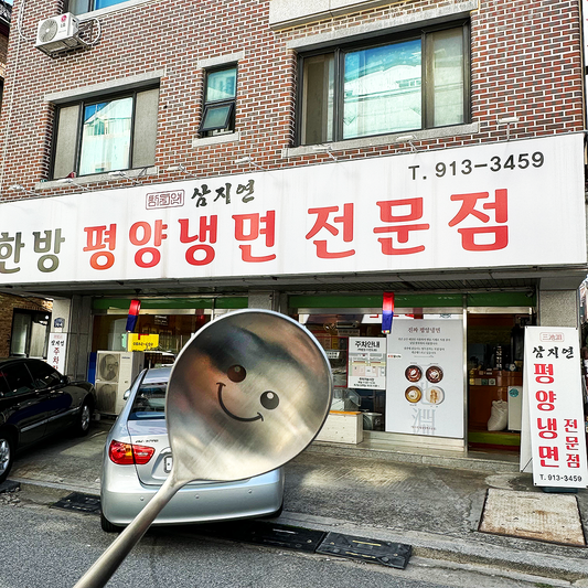 A smiling spoon getting ready to go into a Pyongyang naengmyeon specialty restaurant in Korea