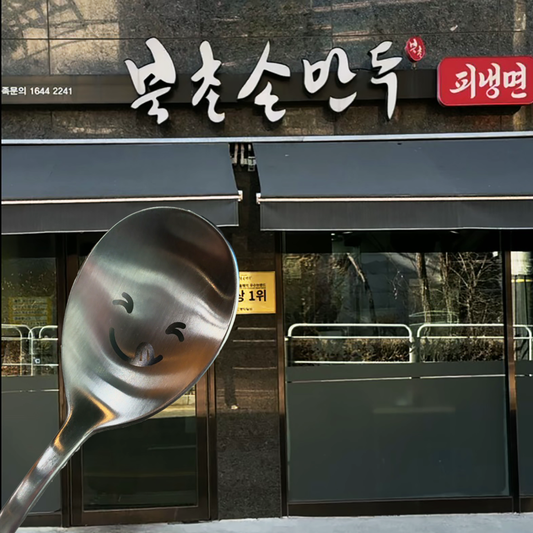 There’s a cute, smiling spoon in front of the "Bukchon Son Mandu" restaurant.