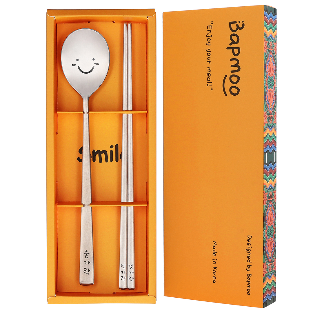 The spoon and chopsticks are placed in a yellow box with a dancheong pattern.
